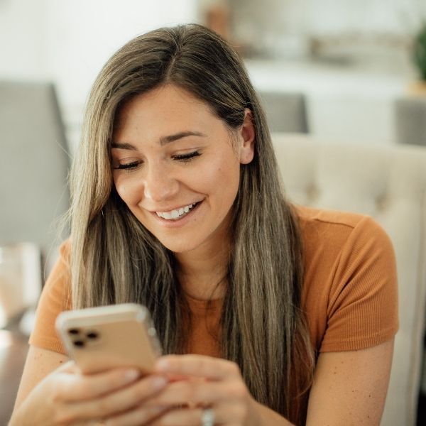 happy woman controlling lights with her phone
